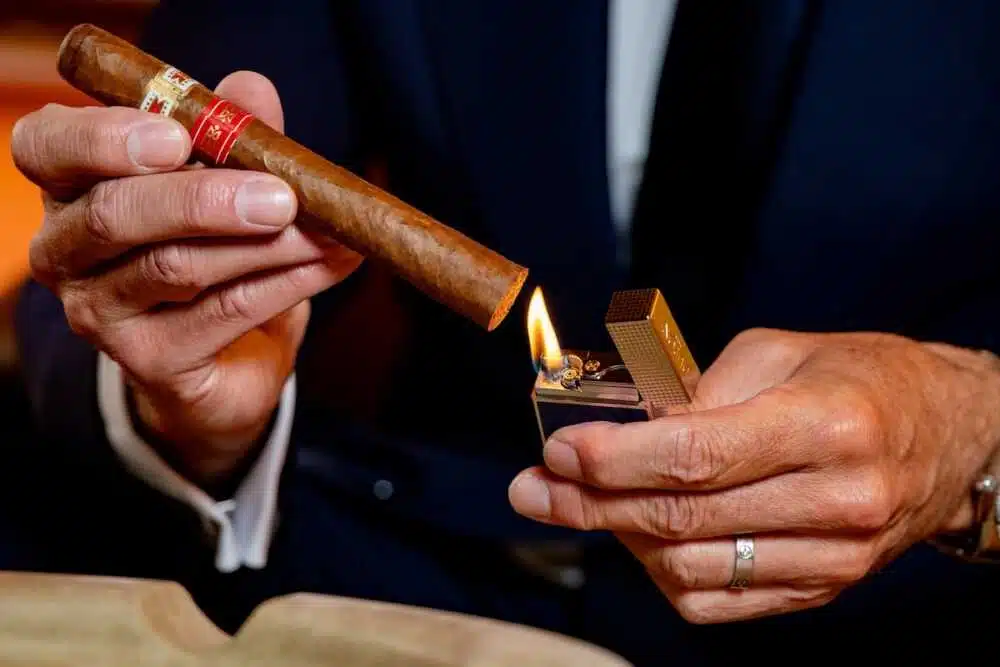 Homme allume un cigare